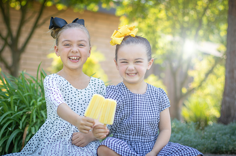 Two girls holding homemade popsicles outside