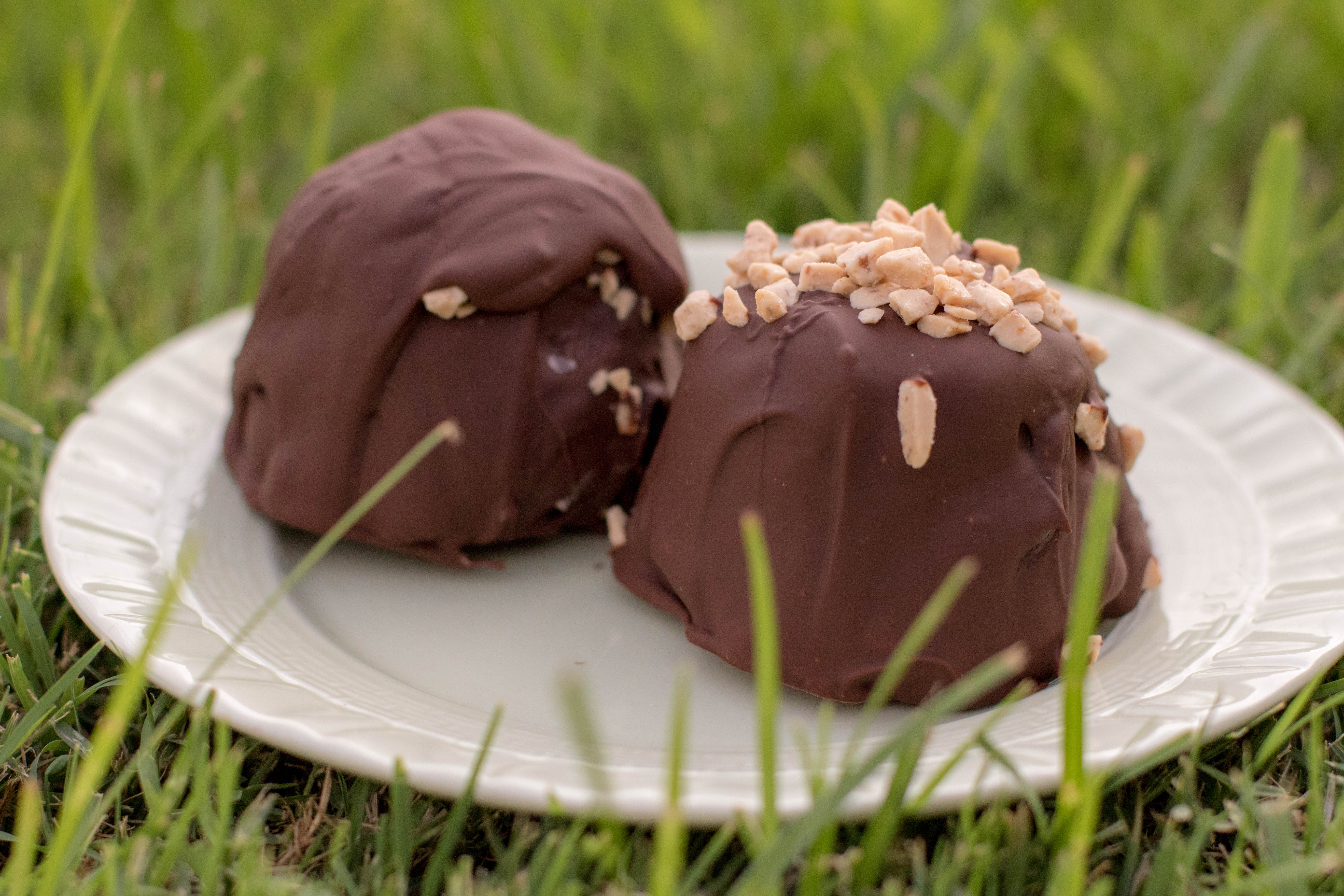 Brownie bombs on a green plate resting on green grass.