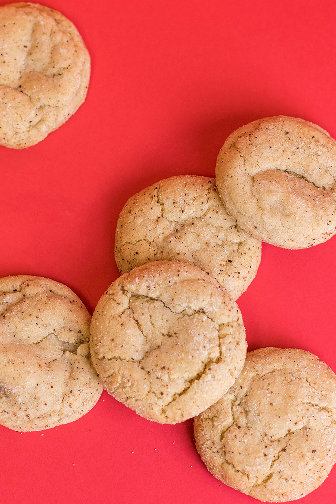 Egg Nog cookies spread out on a red background.